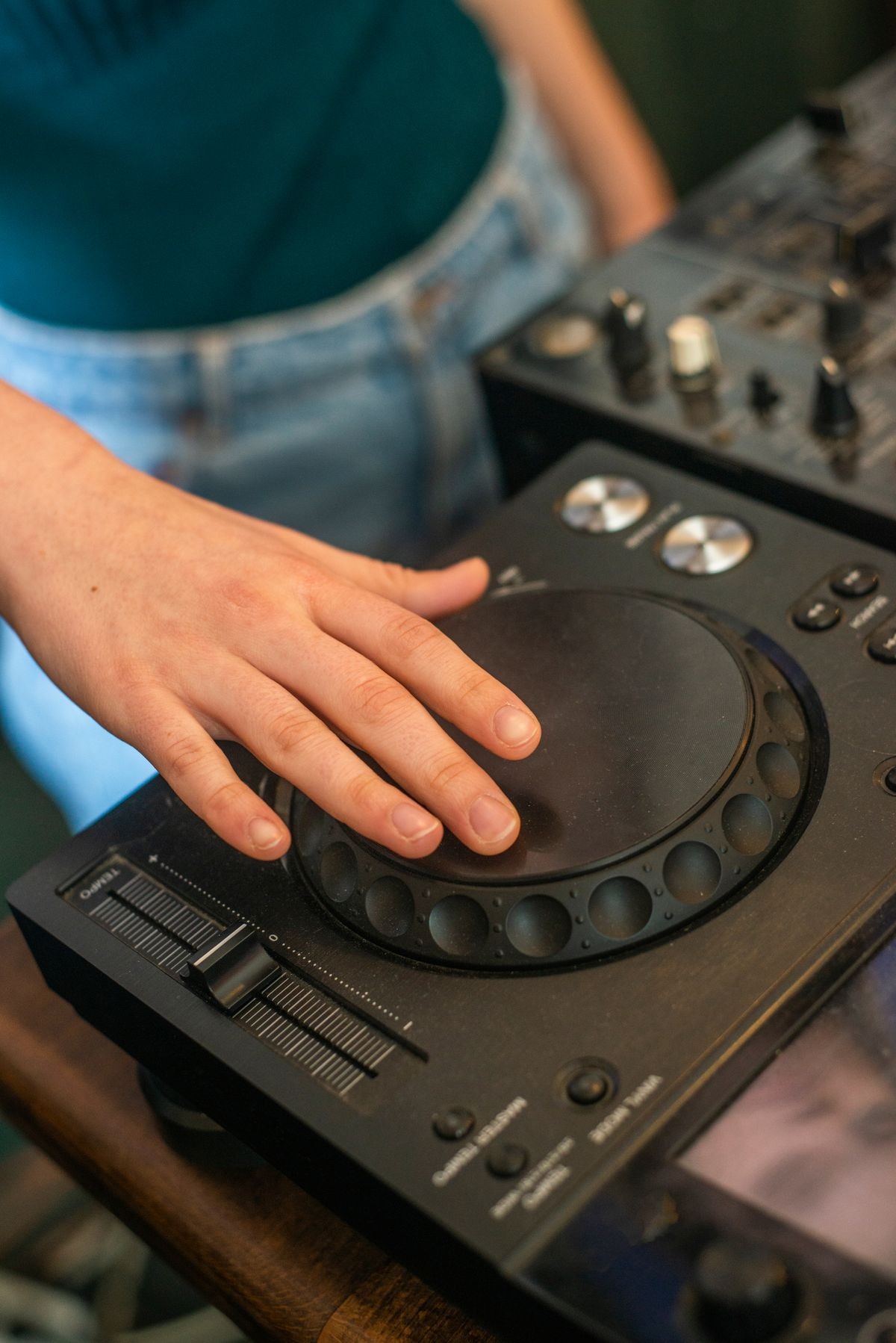 hands of DJs playing on professional board and mixer